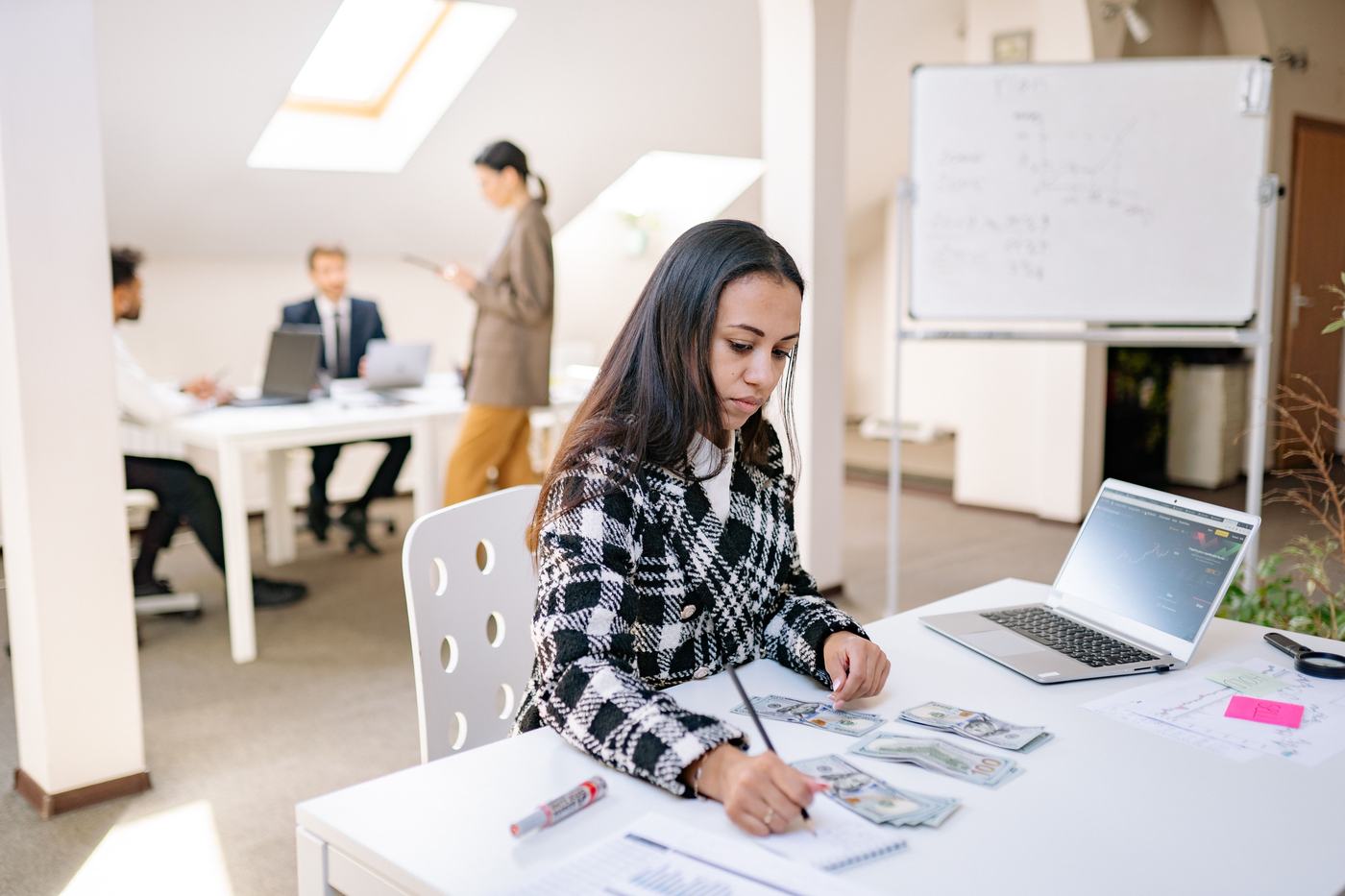 Arbeitsszene in einem Büro, mehrere Personen an Schreibtischen.